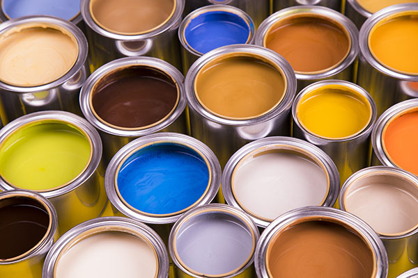 Full Buckets of rainbow colored oil paint on yellow background